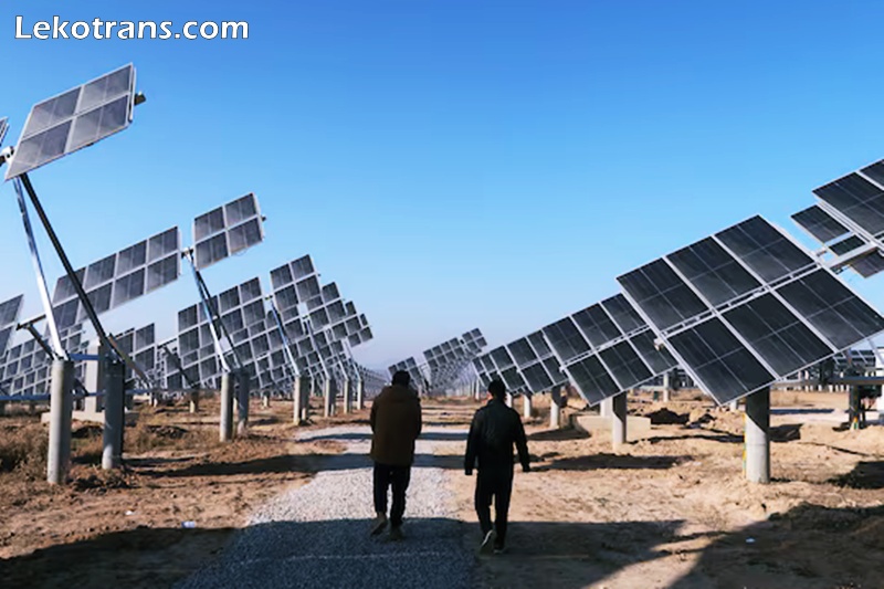 Workers walk at a solar power station in Tongchuan, Shaanxi province, China